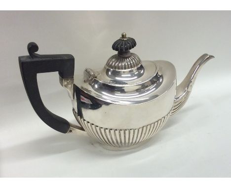 An Edwardian bachelor's half fluted silver teapot. Birmingham. By H&amp;M. Approx. 252 grams. Est. £100 - £150.