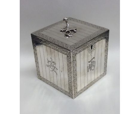 An unusual Georgian silver tea caddy in the form of a cube with fluted body and Chinese lettering, the handle decorated with 