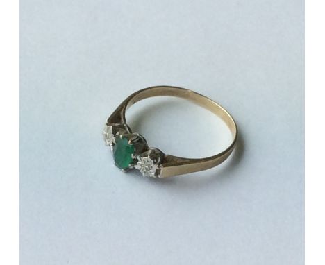 A 9 carat emerald and diamond three stone ring. Approx. 2 grams. Est. £20 - £30.