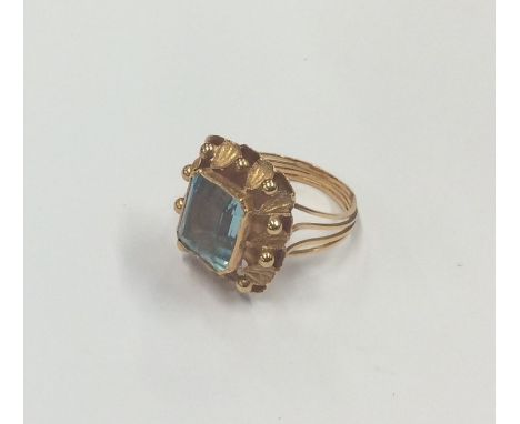 An 18 carat gold blue stone ring with reeded band. Approx. 6.1 grams. Est. £100 - £150.