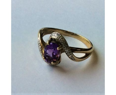 An amethyst and diamond crossover ring in 9 carat mount. Approx. 3.5 grams. Est. £40 - £60.