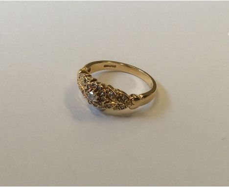 An attractive 14 carat gold diamond cluster ring with scroll decoration. Approx. 4.5 grams. Est. £100 - £150.