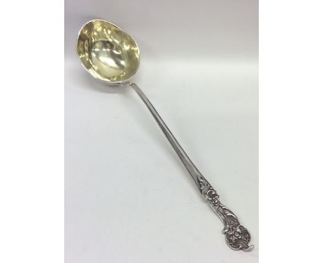 A massive German silver ladle with gilt bowl decorated with scrolls and flowers. Punched to base. Approx. 320 grams. Est. £45