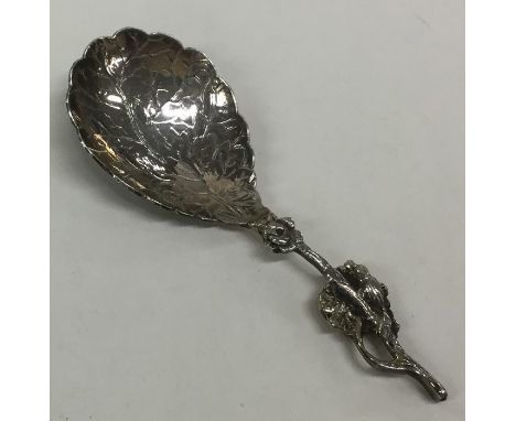 An unusual silver caddy spoon decorated with flowers and leaves. Approx. 11.6 grams. Est. £30 - £50.