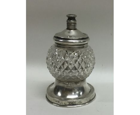 An unusual silver mounted glass sugar caster with push-button mechanism. London. Approx. 142 grams. Est. £40 - £60.
