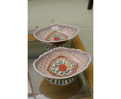 Pair of Oriental ceramic bowls on raised pedestals one with six digit signature panel