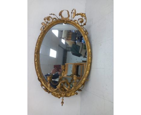 A 19th century Rococo style girandole mirror having the original oval plate in a moulded gilt frame with a scrolling foliate 