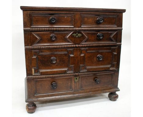 AN OLD OAK CHEST OF TWO SHORT AND THREE LONG DRAWERS with bobbin turned moulding and mitred decoration to the drawer fronts, 