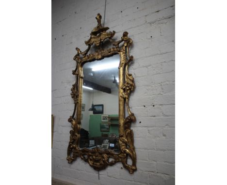 AN EARLY 20TH CENTURY GILT FRAMED WALL MIRROR in the Chinese Chippendale style, the frame with pagoda top with scrolling acan