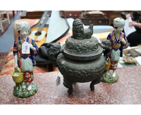 A BRONZED CHINESE STYLE SPELTER INCENSE BURNER AND COVER decorated with Dogs of Fo and with three feet, 33cm high together wi