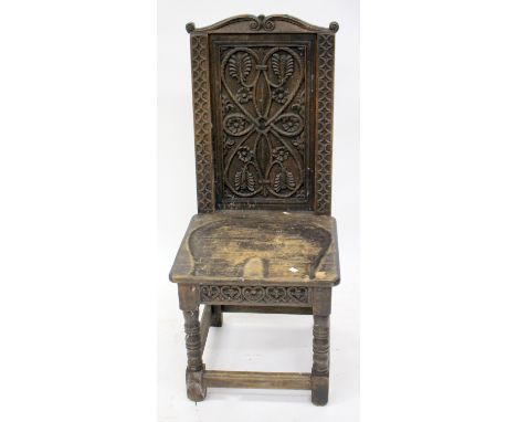 AN EARLY 20TH CENTURY SIDE CHAIR with carved panelled back over a saddle solid seat and standing on ring turned supports unit
