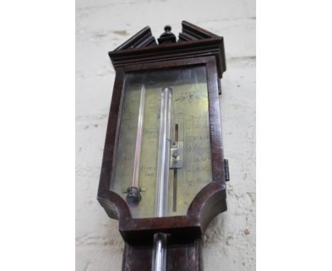 A GEORGE III MAHOGANY STICK BAROMETER with break arch pediment, the stem with boxwood and ebony stringing, the brass dial eng