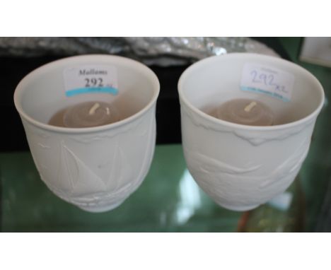 TWO LLADRO BISQUE PORCELAIN CANDLE HOLDERS of beaker form, one decorated with sailing yachts, the other with dolphins, each 9
