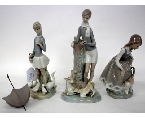 THREE LLADRO PORCELAIN FIGURINES, a girl and a cat, a boy reading to a sheep and a lamb and a girl holding an umbrella with d