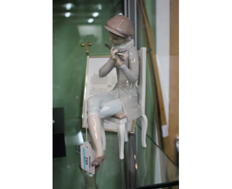 A LLADRO PORCELAIN SCULPTURE OF A YOUNG BOY wearing a ruff, sitting in a chair and playing a flute, 24.5cm high