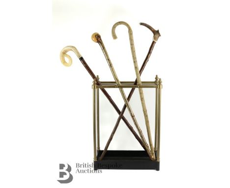 Brass umbrella stand, with drip tray with four walking sticks. The first being a crook with a hazel shaft and polished rams h