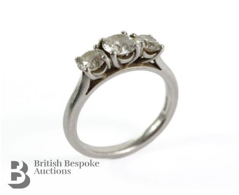 A platinum and diamond ring. The centre stone is approx 55 pts flanked by two diamonds 35 pts, 1.25 ct total, size L, approx 