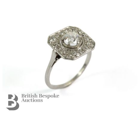 Period Art Deco platinum diamond ring. The ring set with a central diamond 55 pts, G colour, VSI clarity surrounded by a furt