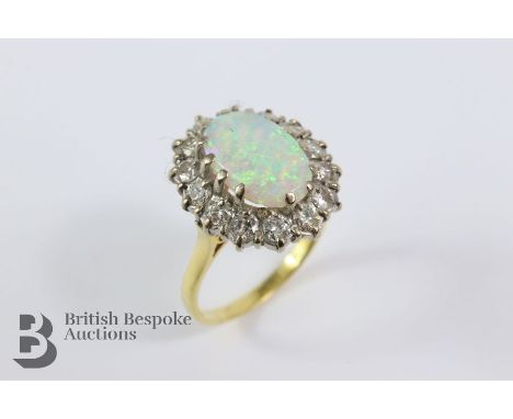 18ct yellow gold opal and diamond ring. The ring set with an oval opal approx 8 x 12 mm surrounded by 72 pts of dias, size P+