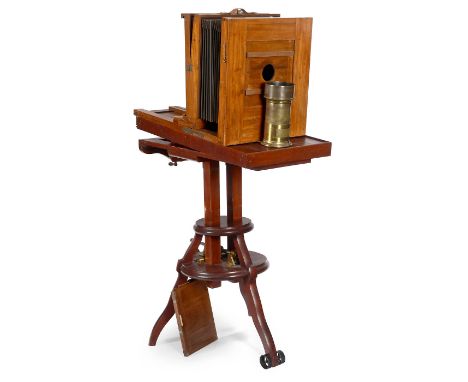 Studiokamera und großes Messingobjektiv, um 1880Deutschland. 1) Dreifuß-Doppelsäulenstativ, Vorderbein mit Rolle, per Kurbel 