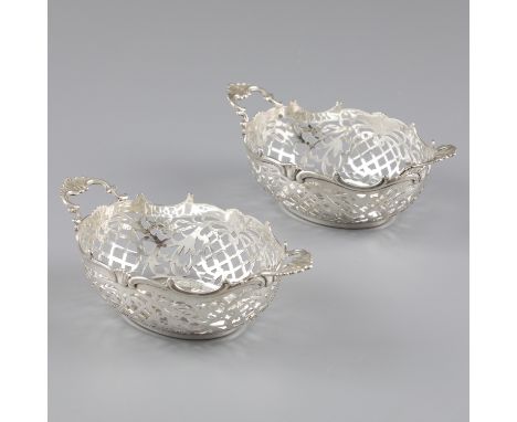 2-piece set bonbon baskets silver. Beautiful set with C-shaped volutes on the top edge and two (on) soldered handles. Openwor