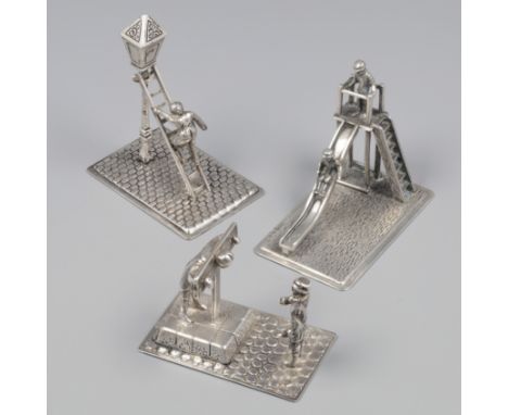 3-piece lot of miniatures silver. Consisting of a lantern lighter, man on scaffold with spectator and a slide with two childr