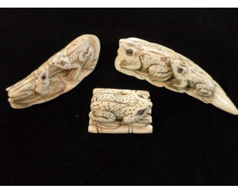 Three Meiji period ivory carved netsuke, each of frogs, two with a pair on leaves and the other a single frog on a bamboo raf