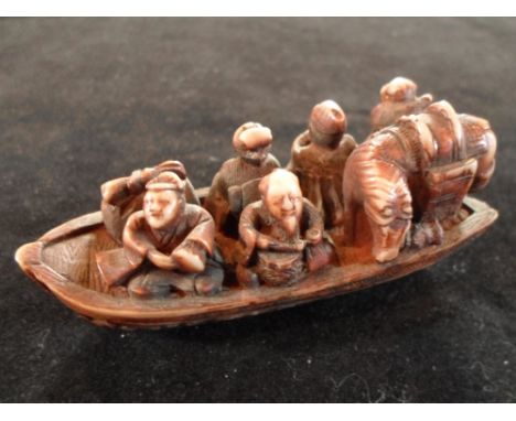 A Meiji period ivory carved netsuke of a heavily packed boat, carrying figures and a horse, 7cm, unsigned