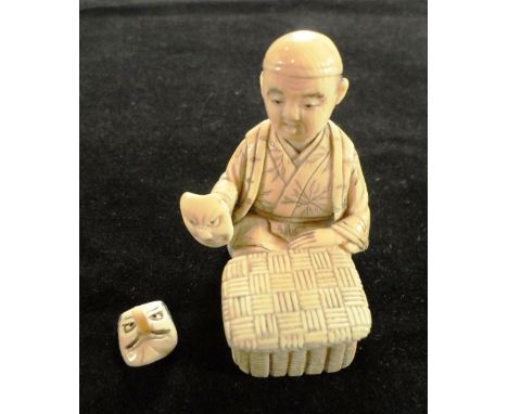 A late 19th century Japanese okimono netsuke of of a seated mask seller, holding a face mask in his right hand, the basket in