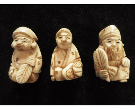 Three 19th century Japanese ivory carved netsuke of seated men, two holding fans