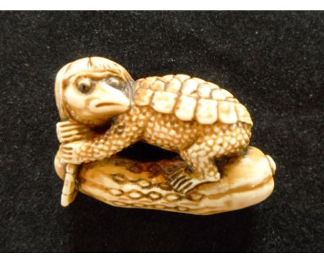 An intriguing 19th century Japanese carved netsuke of a bird disguised as a tortoise, astride a dill pickle, 3.7cm long, sign