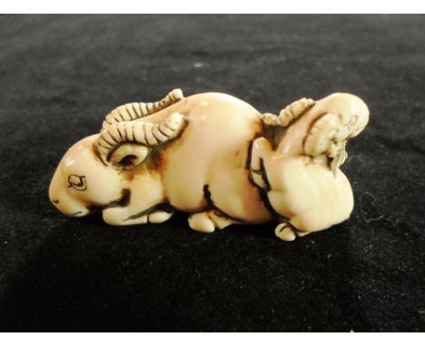 A Meiji period ivory carved netsuke of a mountain goat, with another, smaller at the rear, 5.2cm long, signed