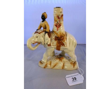 A continental ceramic model of an elephant, fashioned as a candlestick (a/f), impressed marks to base, 16cm tall