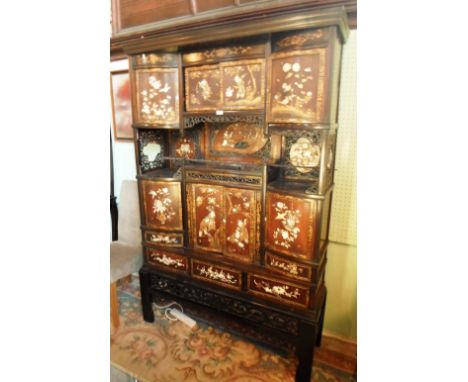 A 20th century oriental floor standing cabinet, having applied bone & mother of pearl decoration in relief, the four door upp