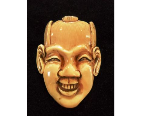 A late 19th century Japanese ivory mask netsuke of a laughing man with top teeth showing, 5cm x 3.9cm, signed