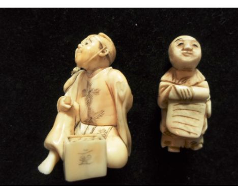 Two Meiji period carved ivory netsuke, one formed as a seated tradesman, the other standing and holding a bed roll, the large