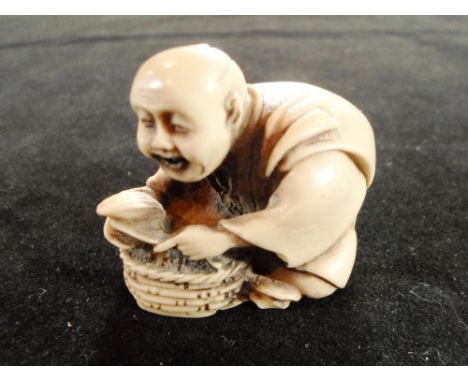 A 19th century carved ivory okimono netsuke of a seated clam seller, 4cm tall, unsigned