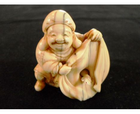 A late 19th century Japanese carved ivory netsuke of a rotund gentleman, revealing a mouse within a large bag, 4cm tall, sign