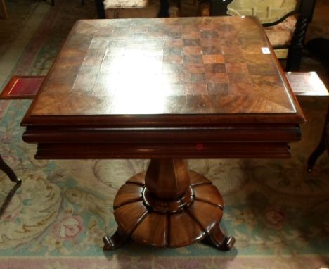 A William IV mahogany and rosewood parquetry square tripod games table, the moulded tilting top inlaid for chess above a deep