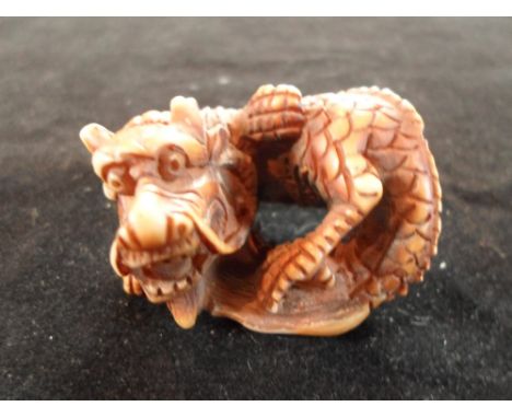 A late 19th century Japanese netsuke, a dragon of circular form, 4cm wide, unsigned