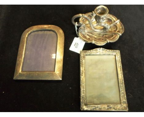 Two silver picture frames, together with a white metal chamber stick, the handle formed as a dragon on a shaped dish