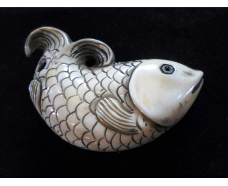 A Meiji period ivory netsuke in the form of a fish, having inlaid eyes and scale decoration, 5.8cm, unsigned