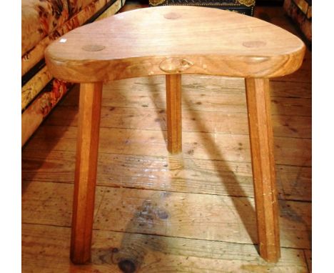 A Robert Thompson, Mouseman, three legged calf stool, having single plank seat and carved mouse on three faceted supports