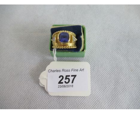 Pippa Ramsay-Rae:  A three stone half-hoop tanzanite and diamond ring, the cushion-cut tanzanite and trapeze cut diamonds in 
