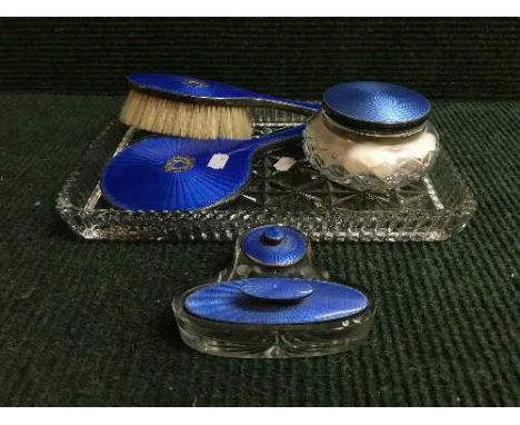 A five piece silver and enamelled dressing table set together with a silver and enamel lidded jar on glass trinket tray