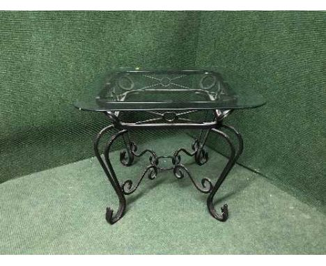 A glass topped wrought iron lamp table 