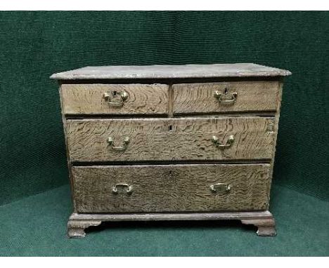 A Georgian oak four drawer chest with brass drop handles on bracket feet 