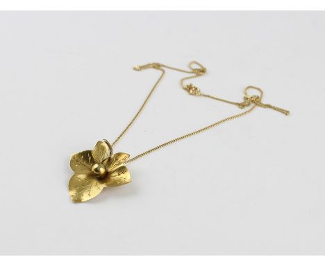 A yellow metal pendant, fashioned as a six bladed leaf with sphere to centre with engraved veins, (yellow metal assessed as 9