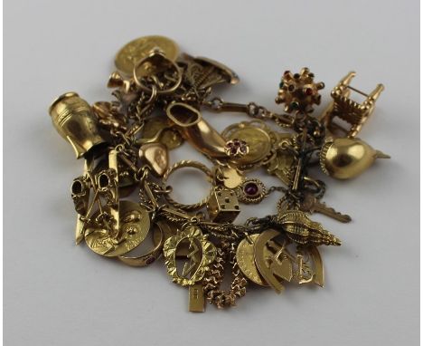 A yellow metal fancy link charm bracelet suspending an extensive collection of high carat gold charms,&nbsp;(yellow metal bra