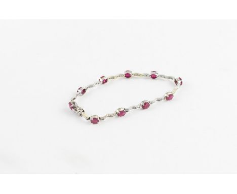 An 18ct. white gold, ruby and diamond bracelet,&nbsp;formed from ten links each four claw set oval cut rubies alternating sha